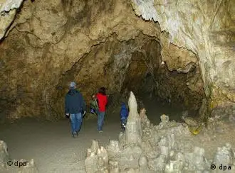 Besucher gehen durch eine Höhle bei Giengen an der Brenz.