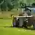 Ein Traktor verspritzt Gülle auf einem Feld. Die Menge von tierischen Dünger kann aber oft nicht von den Böden aufgenommen werden und landet im Grundwasser.