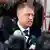 Klaus Iohannis stands in front of reporters' microphones