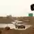 Symbolbild Islamischer Staat: Autos passieren einen Kontrollpunkt, an dem die Flagge des IS weht (Foto: AP)
