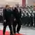 Nawaz Sharif and Angela Merkel walk past an honor guard