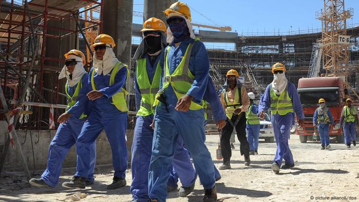 Foreign construction workers qleave a construction site in Doha, Qatar, 19 November 2013