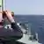 Ein Mann mit Fernglas schaut von dem Patrouillenschiff aufs Meer (Foto: DW/B. Riegert)