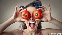 Symbolbild: Eine Frau hält lachend zwei Tomaten vor ihre Augen