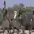 Mitglieder der Boko-Haram Miliz mit schwarzen Fahnen und Waffen