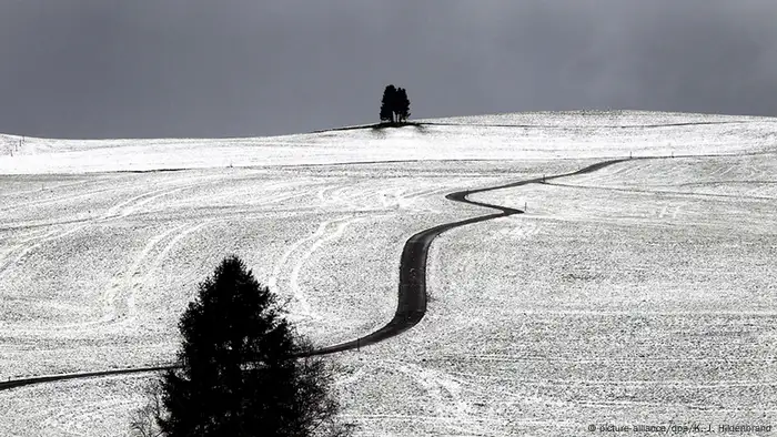 Ein Weg schlängelt sich am durch schneebedeckte Felder