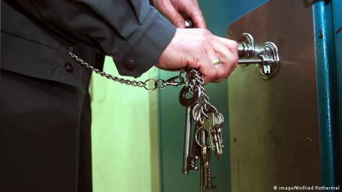 Symbolbild Gefängnis: Ein Vollzugsbeamter steckt einen Schlüssel in eine Zellentür. (Copyright: imago/Winfried Rothermel)
