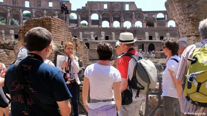 Reiseführer mit Gruppe vor dem Kolosseum Rom