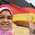Молодая мусульманка на фоне государственного флага ФРГ