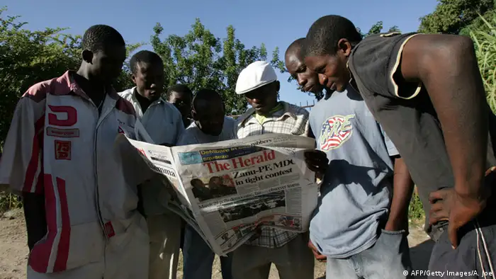 A group of Zimbabweans read a local newspaper