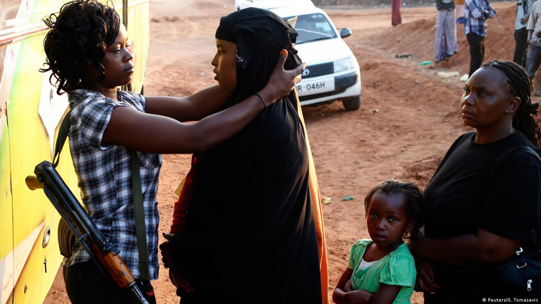 A woman with a rifle searches a woman in a hijab A woman with a rifle searches a woman in a hijab