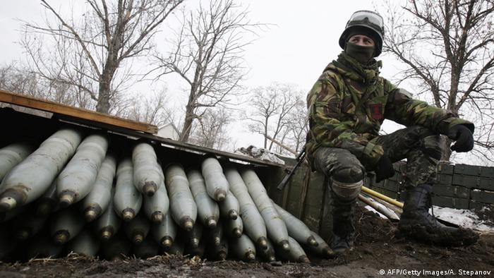 A Ukrainian artilleryman sits near shells at their position near the eastern Ukrainian village Pisky, Donetsk region