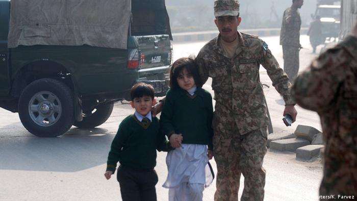 A soldier escorts schoolchildren from the Army Public School that is under attack by Taliban gunmen in Peshawar, December 16, 2014 (Photo: REUTERS/Khuram Parvez)