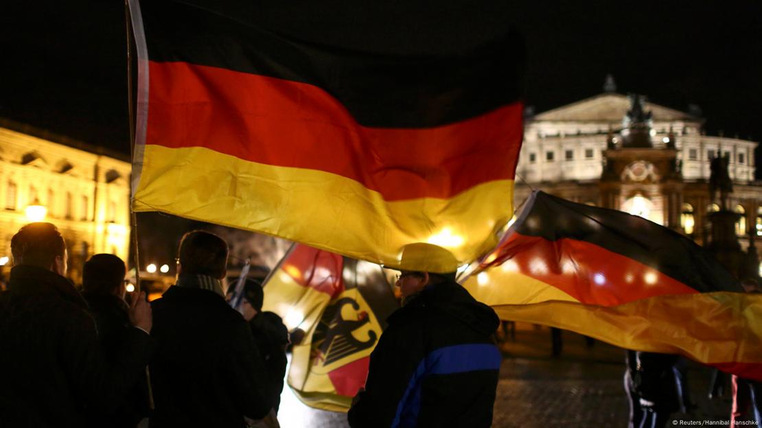 Participants hold German national flags as they gather for a demonstration called by anti-immigration group PEGIDA, a German abbreviation for 