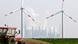 Wind turbines over field with coal plant in the distance Wind turbines over field with coal plant in the distance