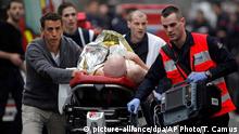 An injured person is evacuated outside the French satirical newspaper Charlie Hebdo's office, in Paris, Wednesday, Jan. 7, 2015. Police official says 11 dead in shooting at the French satirical newspaper. (AP Photo/Thibault Camus)