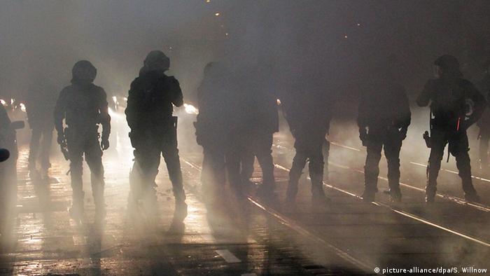 Demonstranten und Polizisten im Gegenlicht von Nachtscheinwerfern(Foto: Sebastian Willnow/dpa)