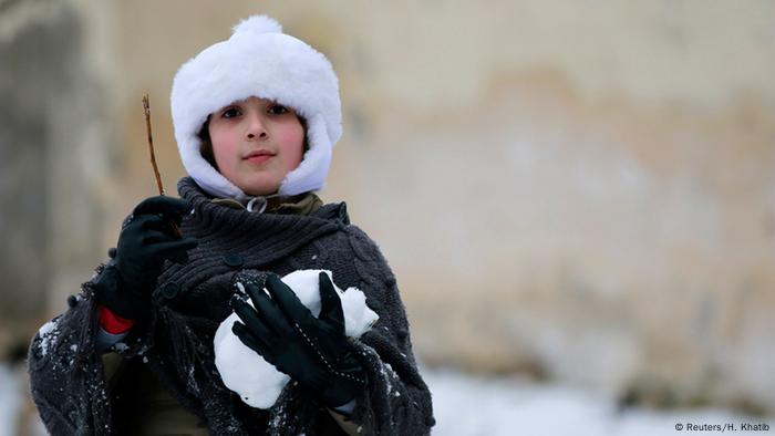 Ein Junge spielt im Schnee in Aleppo, Syrien.