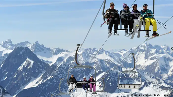 Gondeln mit Skifahrern schweben den Berg hinauf 