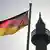 Minarete islâmico ao lado de bandeira da Alemanha