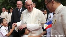 A girl embraces Pope Francis after a welcoming ceremony at the Malacanang Palace in Manila January 16, 2015. Pope Francis called on the Philippine government on Friday to tackle corruption and hear the cries of the poor suffering from scandalous social inequalities in Asia's most Catholic country. At right is Philippine President Benigno Aquino. REUTERS/Ryeshen Egagamao (PHILIPPINES - Tags: POLITICS RELIGION TPX IMAGES OF THE DAY)