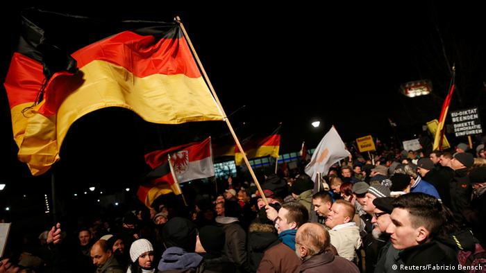 Protesters wave a flag at a PEGIDA march in Dresden