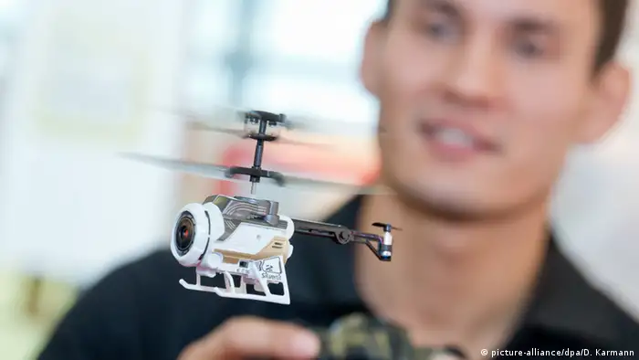 An adult flies a remote-controlled helicopter