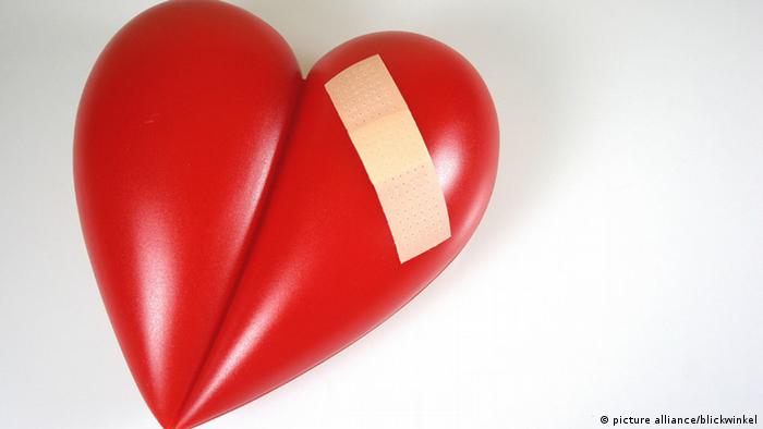 A red heart sculpture with a Band-aid taped on