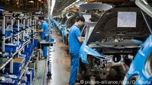 ARCHIV - Mitarbeiter montieren am 11.11.2014 bei einer Besichtigung der Montagehalle im Werk der Volkswagen AG in Anting bei Shanghai (China) Autoteile an einen VW Tiguan. Für die deutschen Autobauer dürfte der weltgrößte Pkw-Markt China laut Experten vermutlich schon in diesem Jahr zum wichtigsten Absatzmarkt aufsteigen - und so der EU den Rang ablaufen. Foto: Ole Spata/dpa (zu lni Studie: Jedes dritte Auto deutscher Hersteller wird in China verkauft vom 02.02.2015) +++(c) dpa - Bildfunk+++