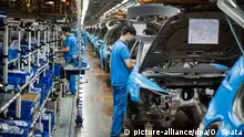 ARCHIV - Mitarbeiter montieren am 11.11.2014 bei einer Besichtigung der Montagehalle im Werk der Volkswagen AG in Anting bei Shanghai (China) Autoteile an einen VW Tiguan. Für die deutschen Autobauer dürfte der weltgrößte Pkw-Markt China laut Experten vermutlich schon in diesem Jahr zum wichtigsten Absatzmarkt aufsteigen - und so der EU den Rang ablaufen. Foto: Ole Spata/dpa (zu lni Studie: Jedes dritte Auto deutscher Hersteller wird in China verkauft vom 02.02.2015) +++(c) dpa - Bildfunk+++