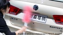 ARCHIV - HANDOUT - Eine Frau säubert am 20.04.2013 auf dem VW-Messestand auf der Auto Shanghai im chinesischen Shanghai das Heck eines Volkswagen Santana. Foto: Friso Gentsch/Volkswagen/dpa (zu dpa: Chinas Kampagne gegen Korruption erreicht Volkswagen vom 27.08.2014) +++(c) dpa - Bildfunk+++