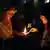 Eine Frau zündet ihre Kerze an einer anderen an (Foto: dpa)