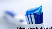 Nahaufnahme einer blauen Zahnbürste mit blau weiß gestreifter Zahnpasta. pixel