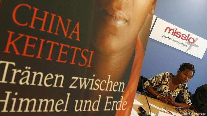 Die Schriftstellerin und ehemalige ugandische Kindersoldatin China Keitetsi stellt in Berlin auf einer Pressekonferenz von UNICEF und Missio ihr neues Buch Tränen zwischen Himmel und Erde vor. Das Buchcover ist vorne links im Bild zu sehen. China Keitetsi selber ist nur ganz klein im Bild unter dem UNICEF-Banner. (Foto: Klaus-Dietmar Gabbert dpa/lbn)
