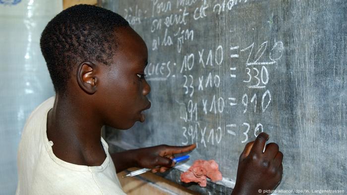 Ein ehemaliger Kindersoldat aus Ostkongo steht an einer Tafel und löst die Rechenaufgabe, die dort angeschrieben ist. (Foto: Wolfgang Langenstrassen)