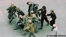 Bergarbeiter verprügeln am 18. Juni 1990 auf offener Straße einen Demonstranten. Rund 8000 Bergleute aus den rumänischen Kohlerevieren kamen nach den gewalttätigen Unruhen in Bukarest Präsident Iliescu zu Hilfe. Sie gingen brutal mit Eisenstangen bewaffnet gegen Demonstranten, aber auch gegen Passanten und Journalisten vor.