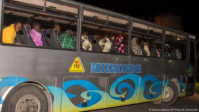 In einem drauen Bus werden die überlebenden Flüchtlinge in ihre Unterkunft auf Lampedusa gebracht. Hinter den Fesntern sitzen nur Mjunge Männer. (Foto: AP Photo/Mauro Buccarello)