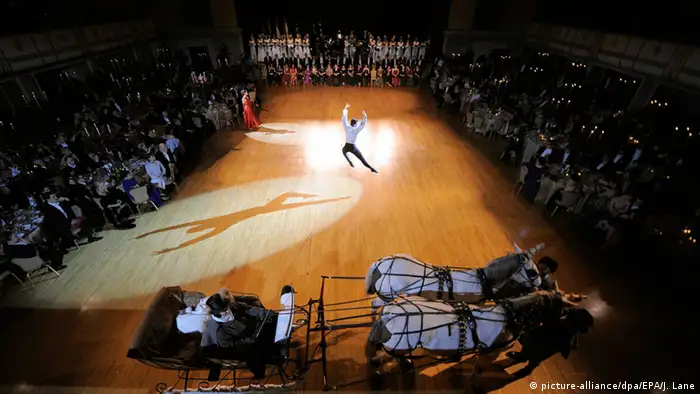 Auf einem Platz in New York tanz ein Balletttänzer. Das Publikum am Rand schaut zu. Vorne ist eine weiße Kutsche mit zwei Schimmeln zu sehen. (Foto: picture-alliance/dpa/EPA/J. Lane)