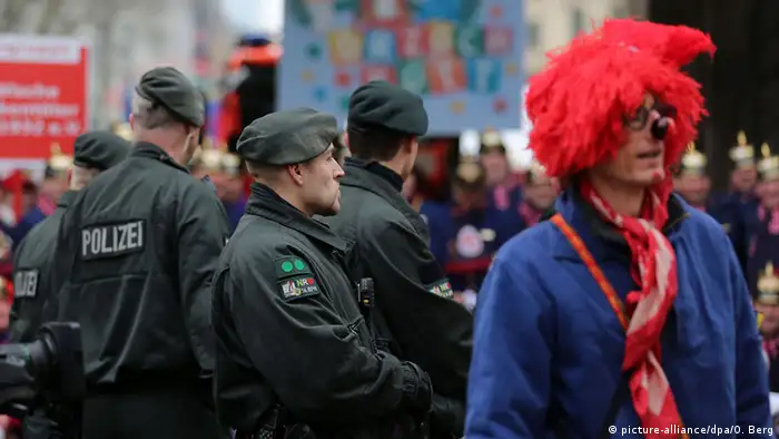 Polizisten neben Karnevalisten am Rosenmontags-Zugweg in Köln, Foto von Oliver Berg/dpa