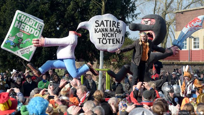 Der Charlie Hebdo Wagen beim Rosenmontagszug in Düsseldorf. Eine Figur mit abgehacktem Kopf hält die Zeitschrift Charlie Hebdo in der Hand, dahinter eine maskierte Figur mit einem Krummsäbel. Karneval 2015 Rosenmontag Charlie Hebdo (picture-alliance/dpa/F. Gambarini)