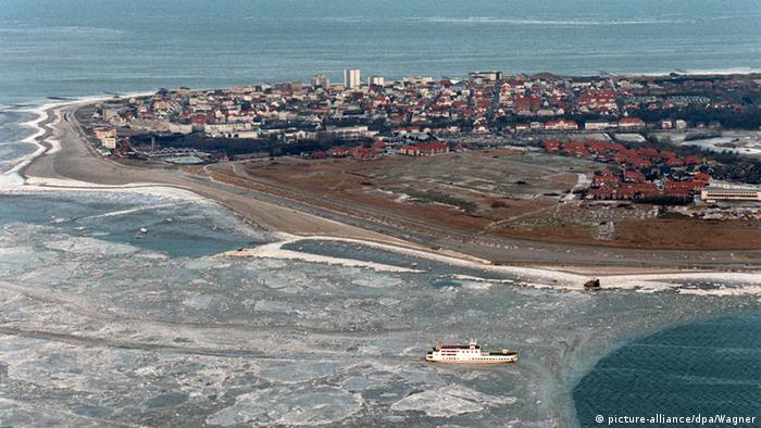 An areal view of Norderney, with many buildings and part of the water frozen over. 
