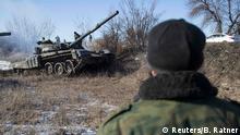 A man watches a tank of the separatist self-proclaimed Donetsk People's Republic Army manoeuvre near a checkpoint on the road from the town of Vuhlehirsk to Debaltseve February 18, 2015. REUTERS/Baz Ratner(UKRAINE - Tags: POLITICS CIVIL UNREST CONFLICT MILITARY)