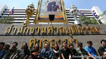 Demonstrierende Studenten in Bangkok unter einem Porträt des Königs (Foto: Reuters/Damir Sagolj)