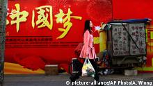 A woman carries a bag of groceries as she walks past a Chinese government billboard stating China Dream near a residential building in Beijing, on Thursday, Feb. 26, 2015. Since taking the reins of the ruling Communist Party in 2012, President Xi Jinping has leveraged slogans to promote his program of strengthening party rule, cracking down on corruption and building up China¿s international standing. The most famous of these has been the Chinese Dream, a fuzzy concept that seeks to motivate the nation¿s 1.3 billion people to realize prosperity, happiness and their rightful place on the world stage. (AP Photo/Andy Wong)