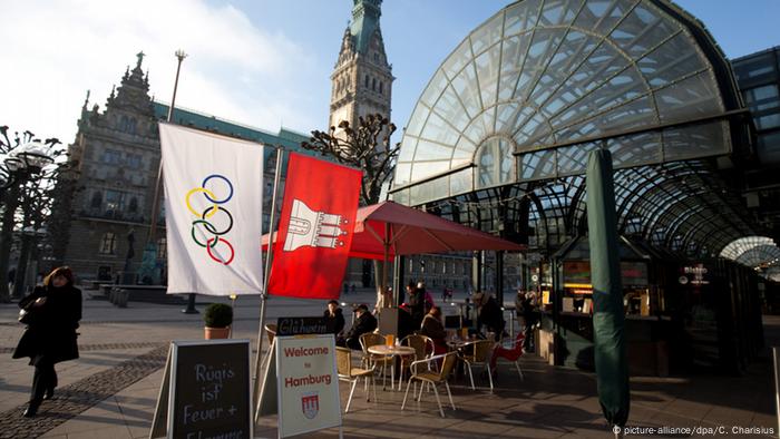 Hamburger und Olympia-Flagge vor einem Gebäude in der Hansestadt. Foto: dpa-pa