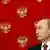 Владимир Путина на фоне изображенных на стене гербов России