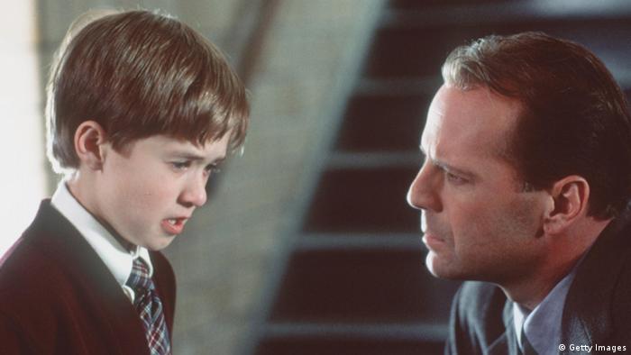 Film still The Sixth Sense, man looks at a young boy who is talking to him 