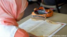 Ganztagshauptschule (GHS) Aachen-Aretzstrasse. Schulprojekt in einem sozialen Brennpunkt der Stadt mit besonderen Förderprogrammen und pädagogischen Konzepten ('Schule als Lebenswerkstatt'). Die Hälfte der 500 Schüler stammt aus Einwandererfamilien und nur jeder sechste Schüler ist mit Deutsch als Muttersprache aufgewachsen. Hier: Eine muslimische Schülerin während des Deutschunterrichts. Das Mädchen trägt das traditionelle Kopftuch. Aachen, Nordrhein-Westfalen, Deutschland, 14.06.2006