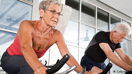 Older couple in gym on ergometer