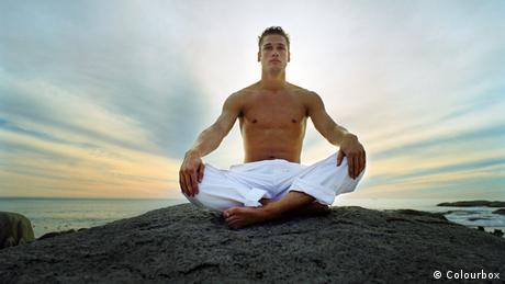 Man sitting meditating on rocks
